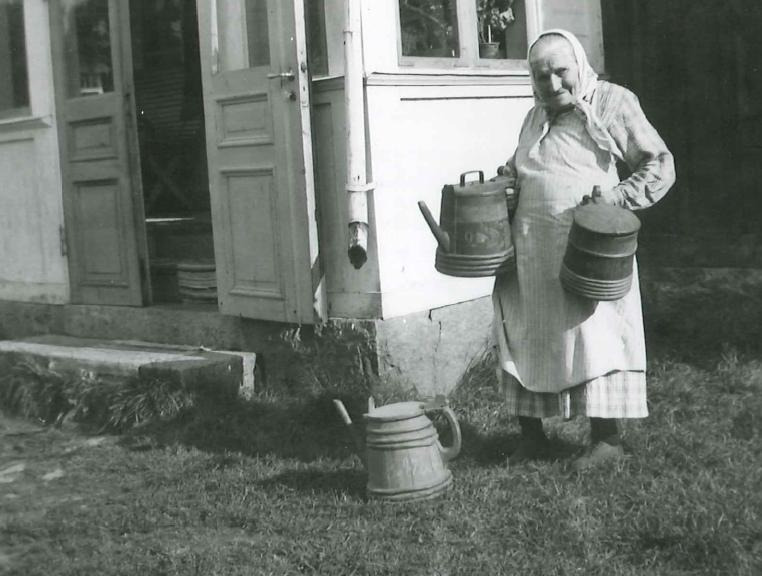 Ulrika Eriksson visar upp träkannor för dryck. Forsa, Hälsingland år 1938.
