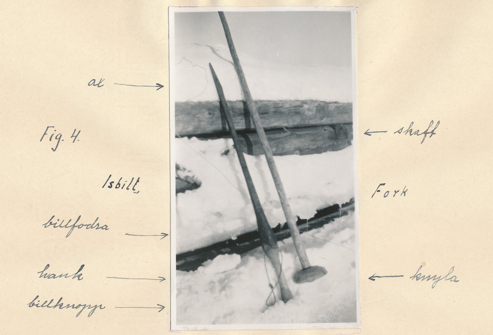 Svartvitt fotografi föreställande redskap uppställda i snön. Fotografiet är uppklistrat på ett papper där det står förklaringar till varje redskap.